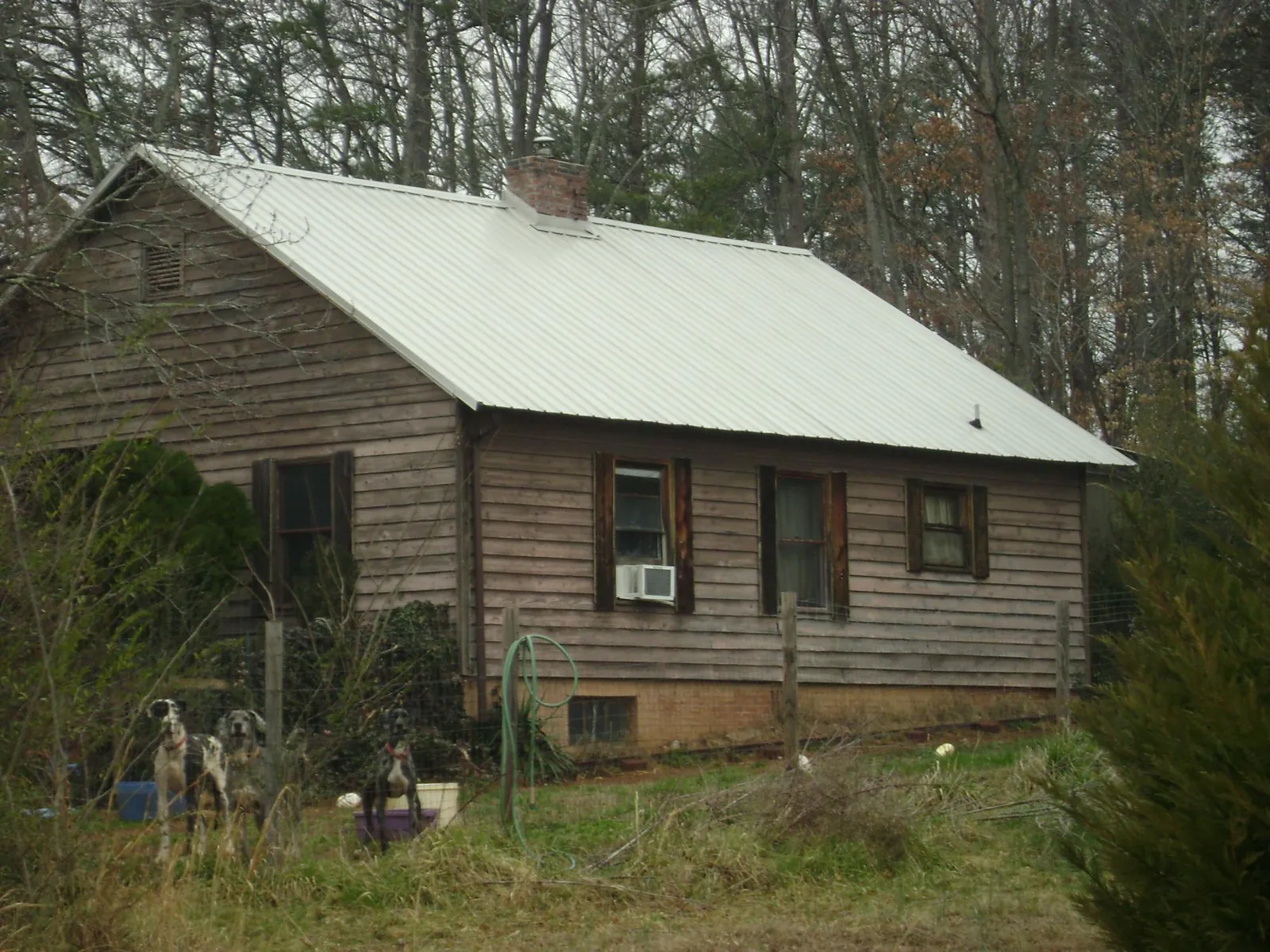 White metal roof on an old wood sided farmhouse, from a Metal Roof Installation job in Millsboro
